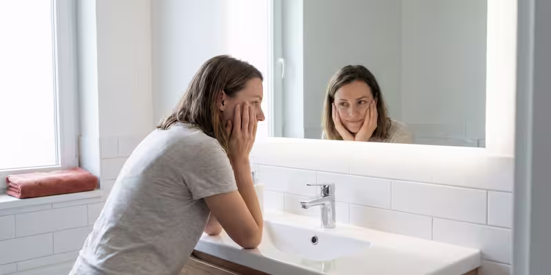 Mujer con depresión funcional mirándose al espejo.